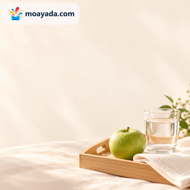 تفاحة خضراء وكأس ماء على صينية صغيرة فوق خلفية بيضاء دافئة