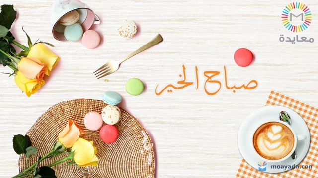 بطاقة صباح الخير تضم فنجان قهوة برغوة على شكل ورقة وورود صفراء وحبات ماكرون ملونة.